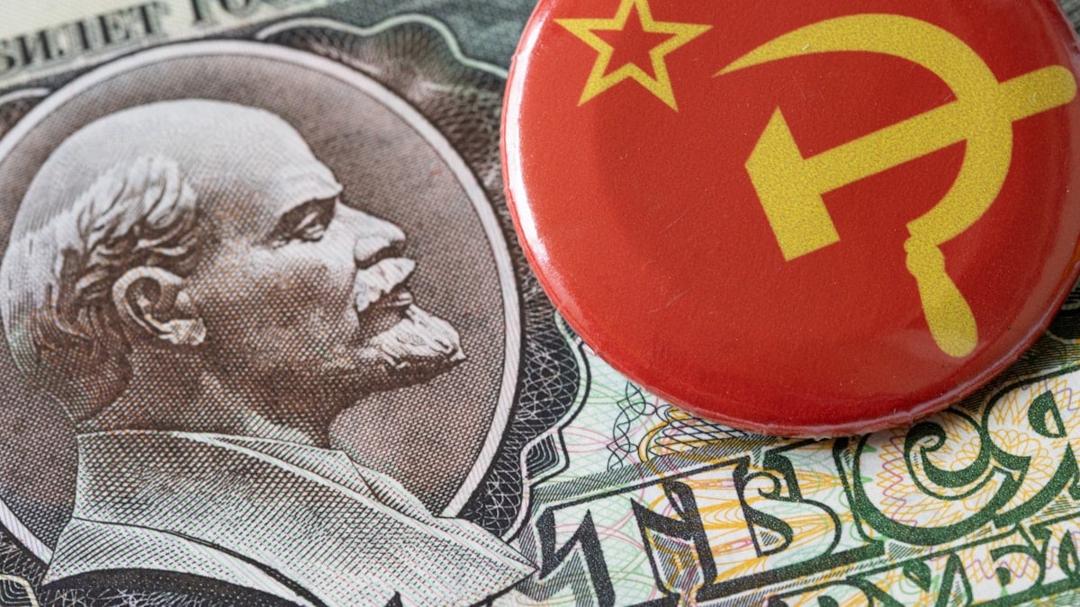 a red button sitting on top of a pile of money